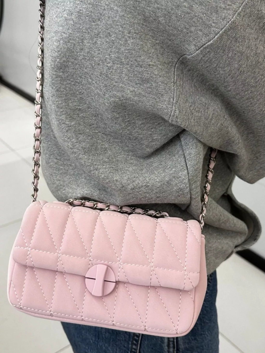 Mini quilted flap chain bag in pink with a crossbody strap.