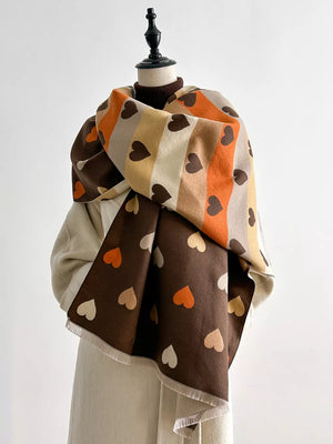 Cozy scarf with brown, beige, and orange stripes and scattered heart pattern.