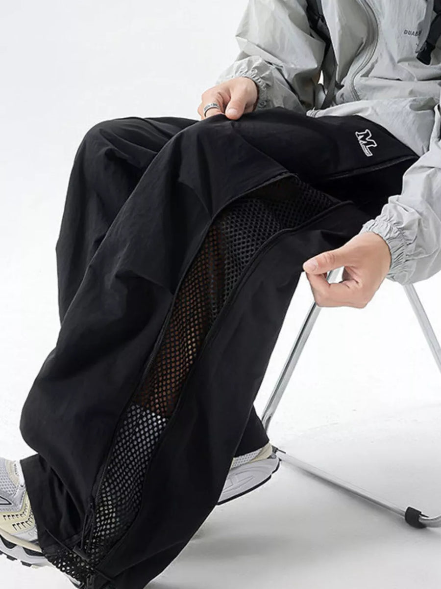 Black cargo sweatpants with mesh side panels and adjustable waist.