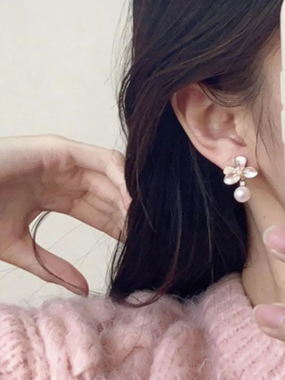 Pearl blossom drop earrings with delicate petals and a single pearl accent.