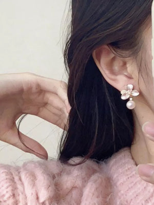 Pearl blossom drop earrings with delicate petals and a single pearl accent.