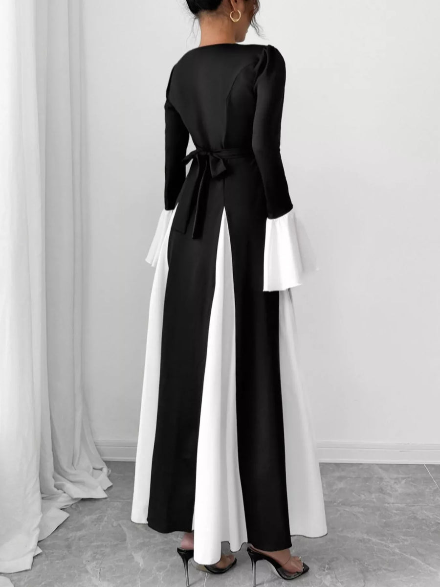 Black maxi dress with tie waist and flare sleeves, featuring contrasting white panels.