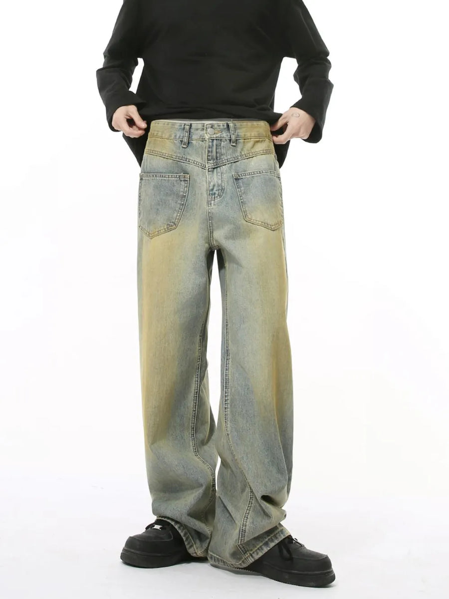 Distressed denim jeans in a medium wash with a relaxed fit and vintage fade.