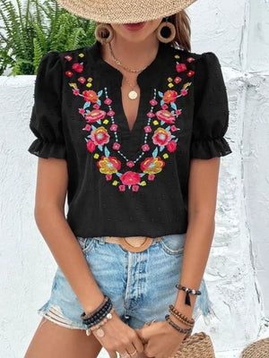 Black embroidered blouse with puff sleeves and floral neckline detail.