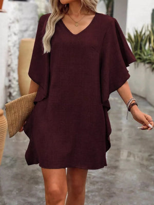 Wine red V-neck mini dress with flowy sleeves and a textured fabric.