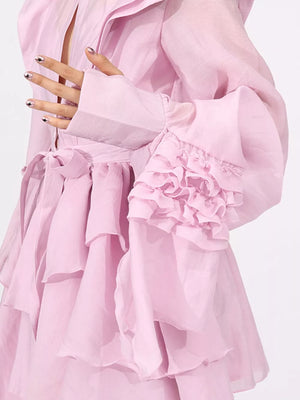 Pink tiered ruffle mini dress with button-down detail and ruffled bell sleeves.