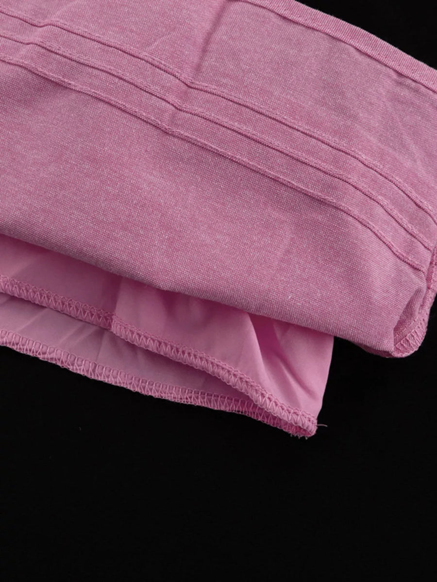 Pink textured fabric top with ribbed detail and ruffled hem.
