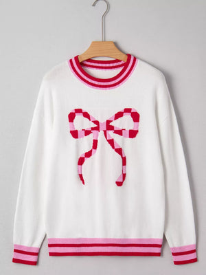 White round-neck sweater with a pink and red checkered bow graphic and striped cuffs and hem.