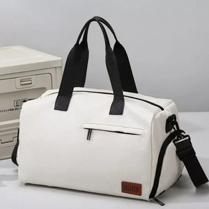 Creamy-white nylon travel duffel bag with black straps and adjustable shoulder strap.
