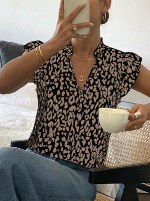 Leopard print blouse with ruffled cap sleeves and a mock neck, paired with blue jeans.