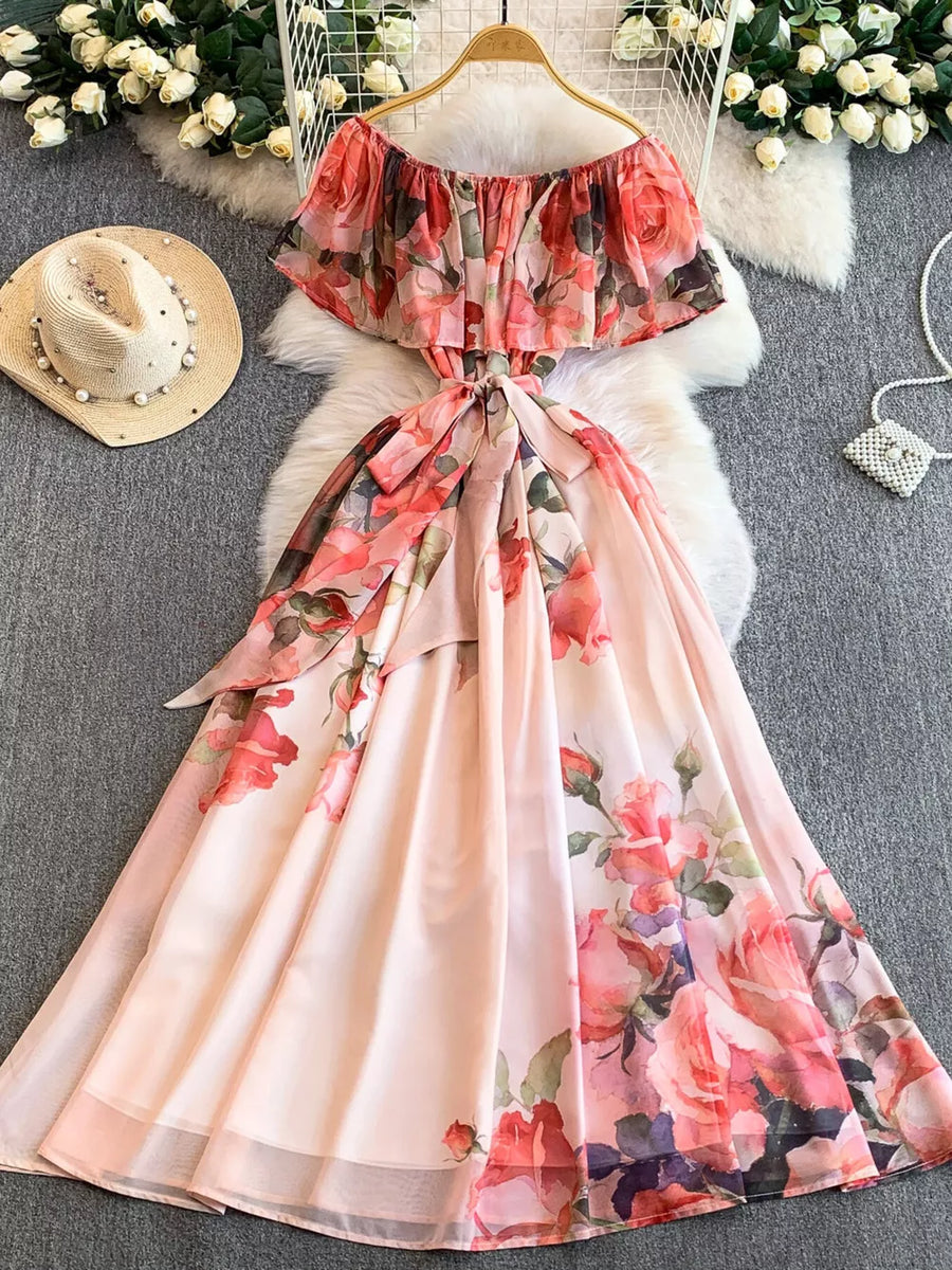 Botanical off-shoulder a-line dress in light pink with floral print and belted waist.
