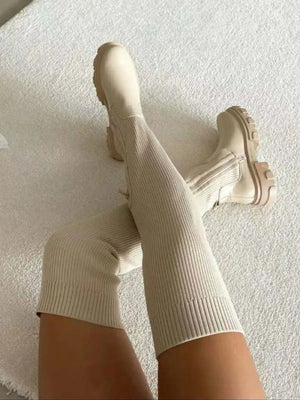 Beige knit-top platform over-the-knee boots with a ribbed texture and chunky sole.