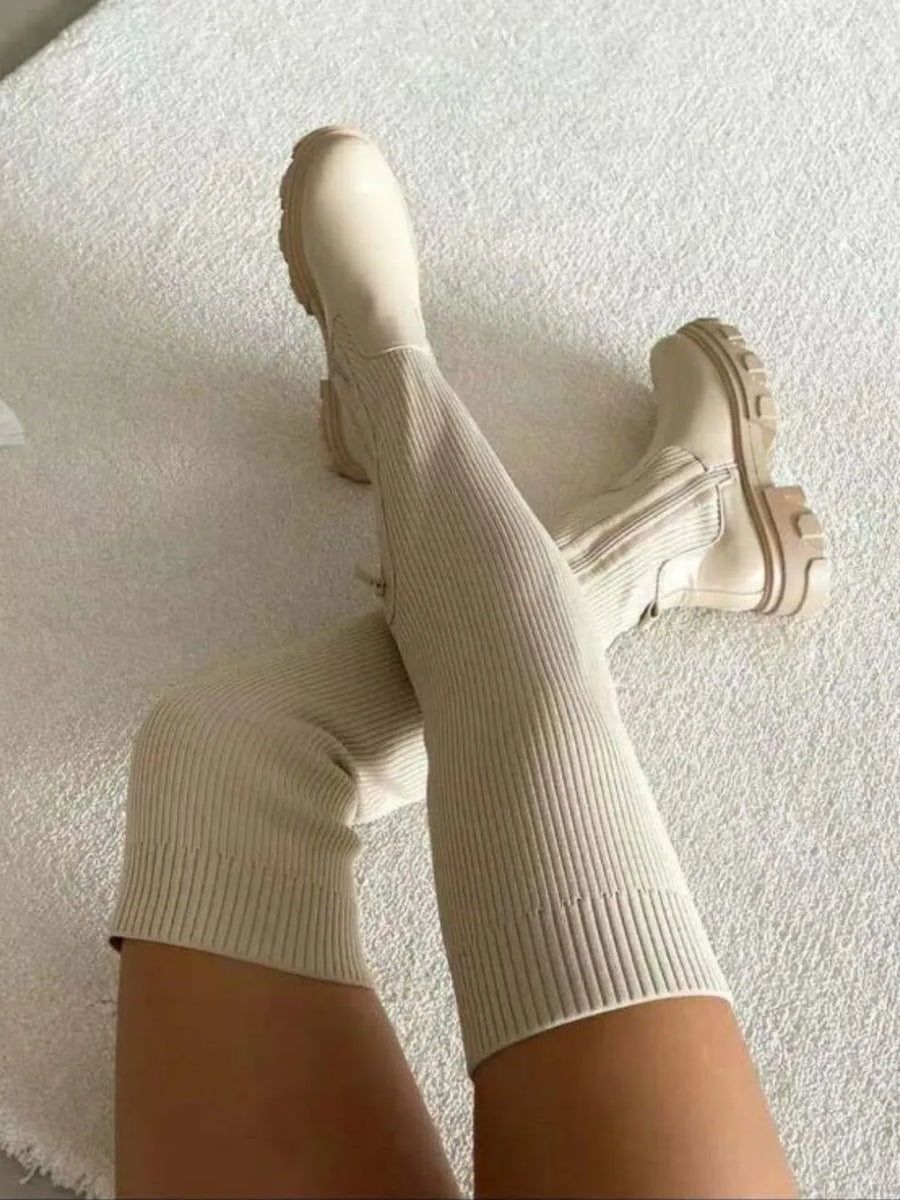 Beige knit-top platform over-the-knee boots with a ribbed texture and chunky sole.