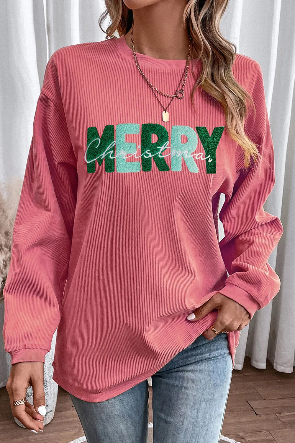 Burnt coral corduroy sweatshirt with "Merry Christmas" graphic.