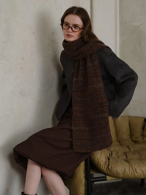 Textured mélange knit scarf in Chocolate, styled with a dark gray jacket and brown dress.