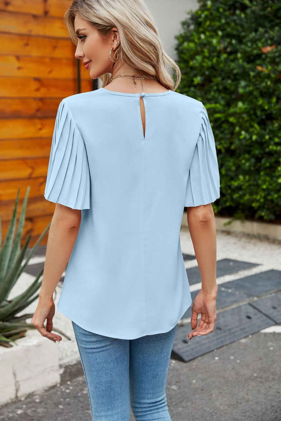 Pastel blue blouse with short pleated sleeves and keyhole back detail.