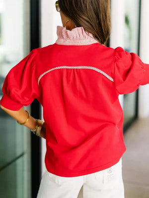 Red cotton blouse with puff sleeves, ruffled collar, and decorative rope trim.