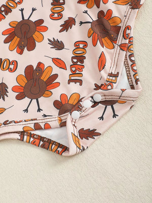 Baby bodysuit with Thanksgiving turkey and fall leaf print, featuring snap closures.