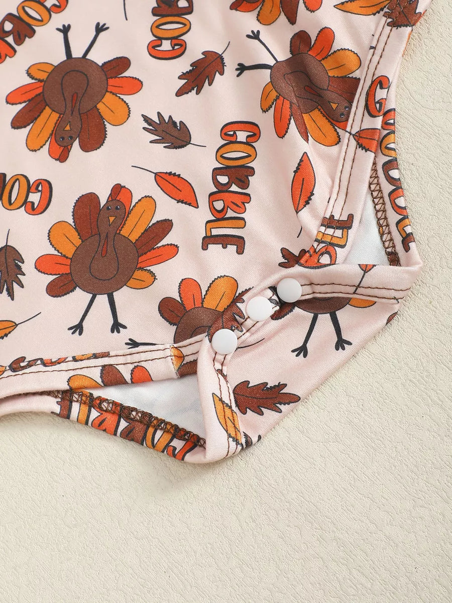 Baby bodysuit with Thanksgiving turkey and fall leaf print, featuring snap closures.