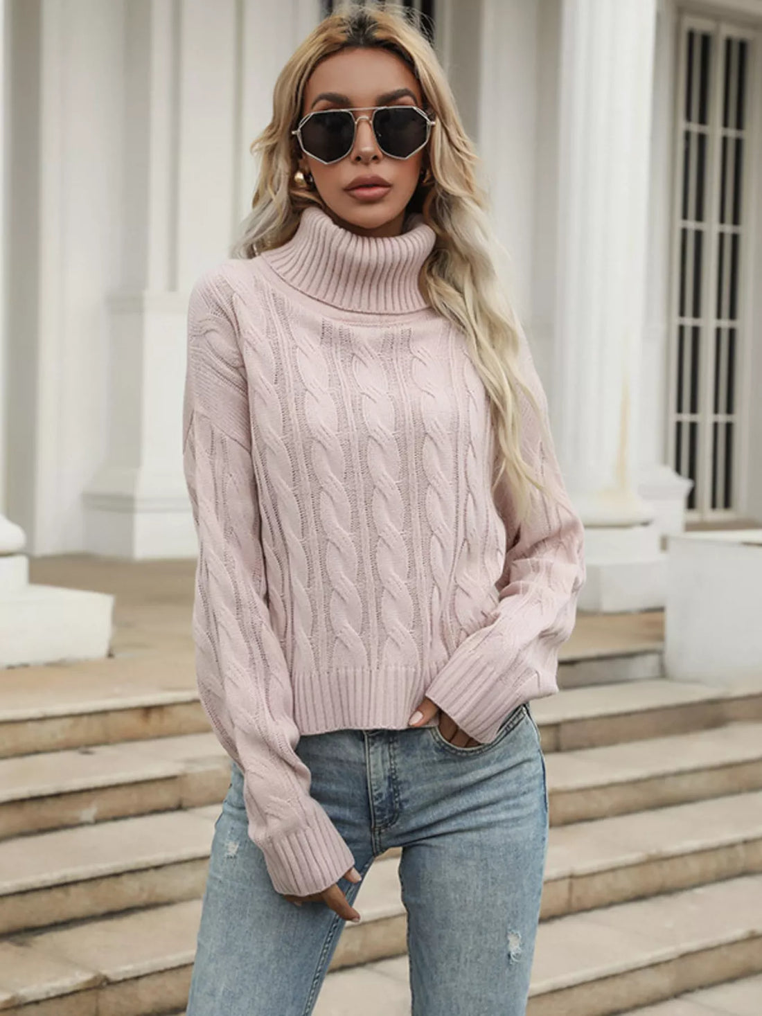 Pink cable knit turtleneck sweater with a cozy, casual style.