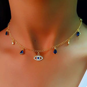 Gold evil eye charm necklace with blue teardrop accents and a delicate chain.