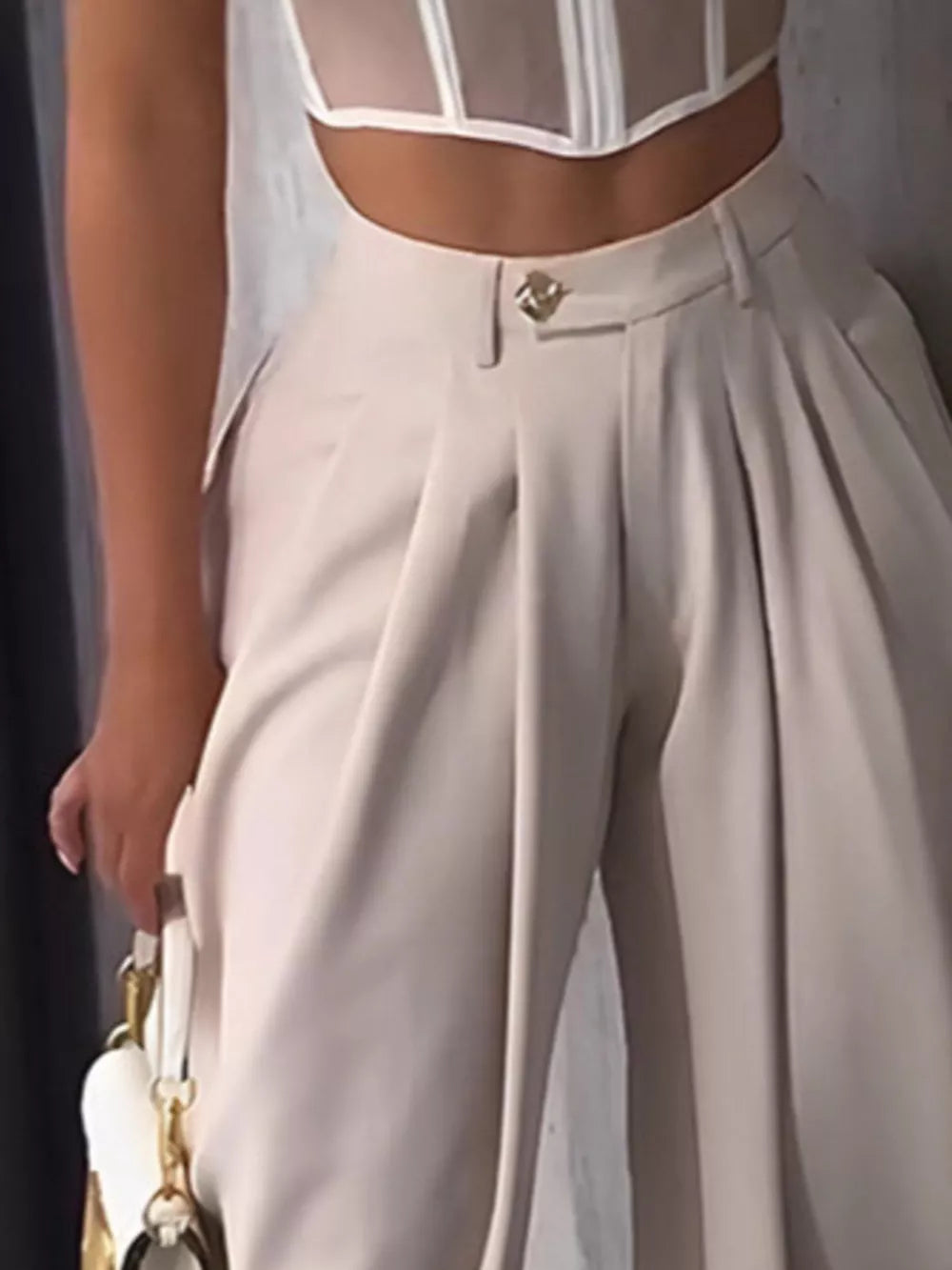 Light Khaki sculptural pleated high-waisted pants with button detail.