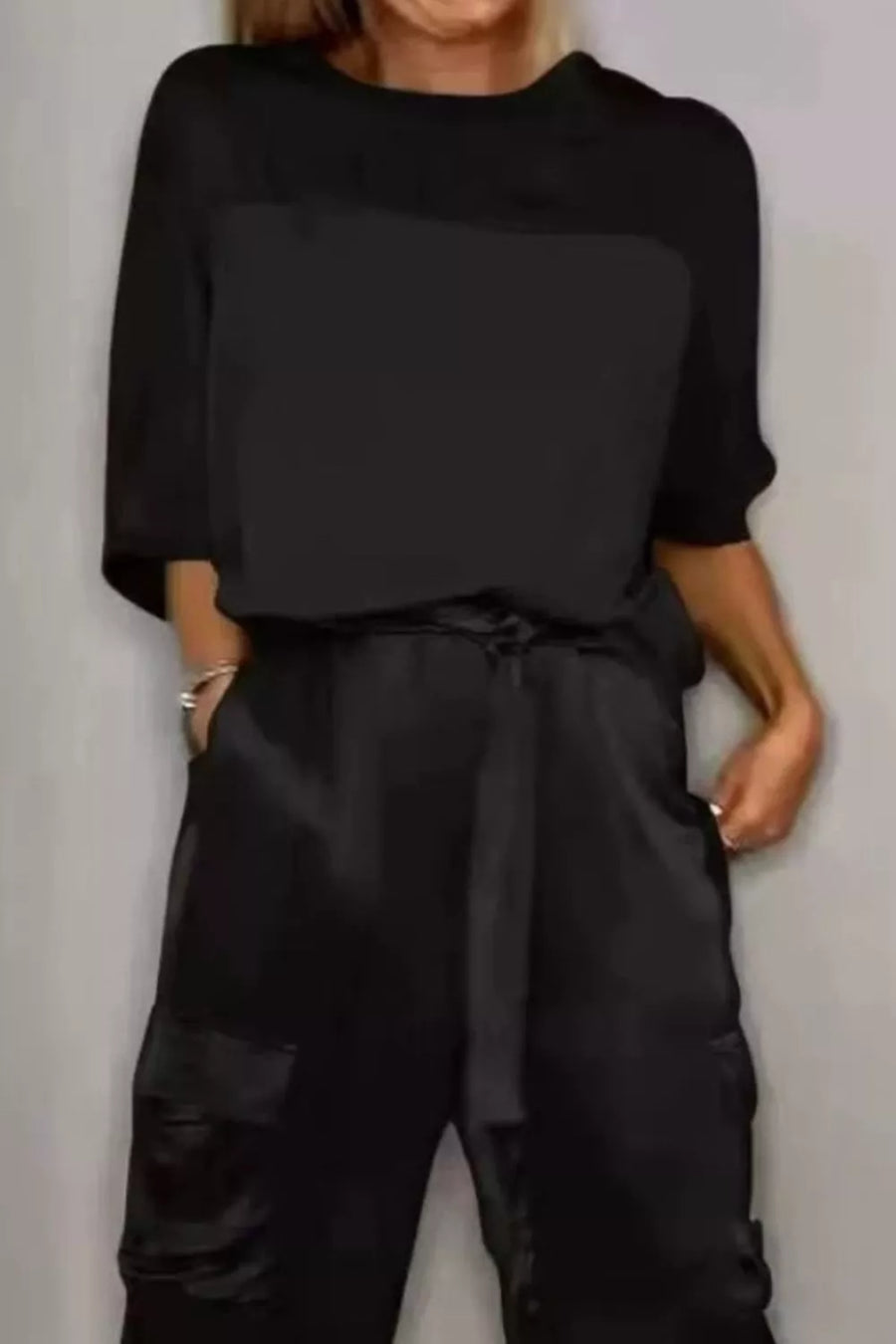 Black satin two-piece outfit set with a tie waist and cargo pockets.