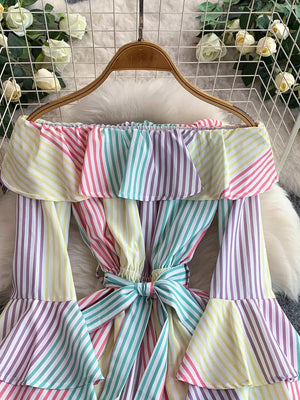 Off-shoulder ruffled romper in Color Strips with a belted bow detail.