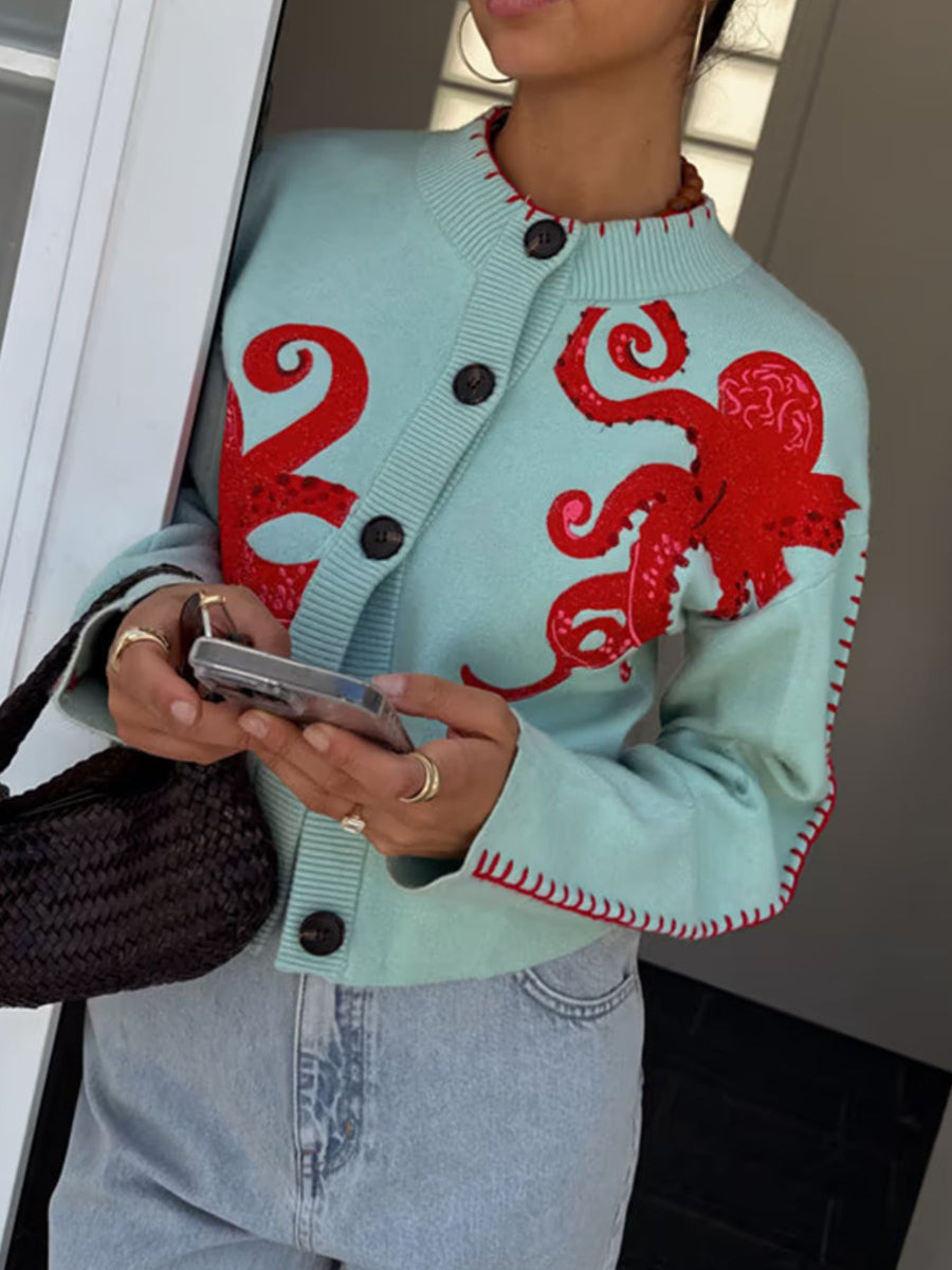 red cardigan featuring contrast stitching and octopus graphic