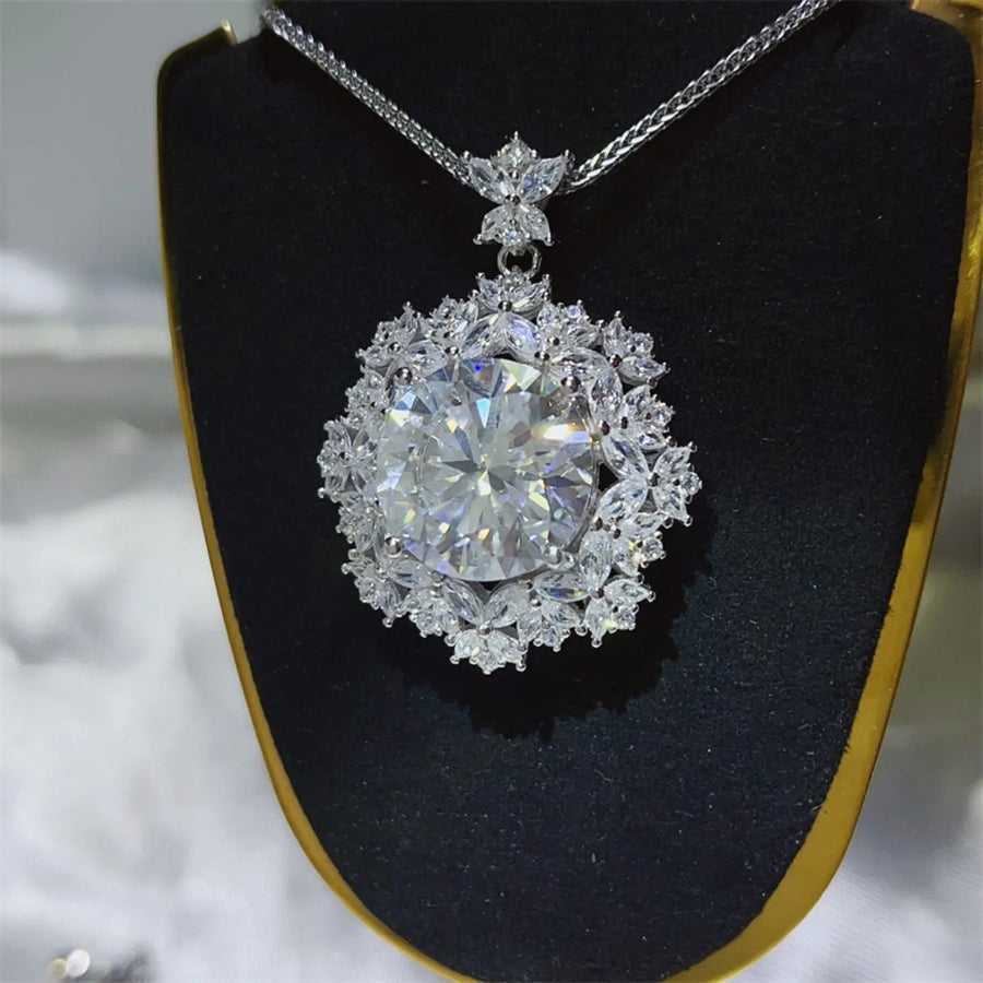 Radiant white cluster pendant necklace with large central stone and floral halo.