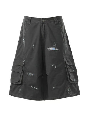 Black distressed cargo capris with multiple pocket details and plaid lining accents.