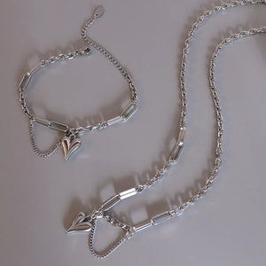 Silver heart drop chain link necklace with delicate chain detail.
