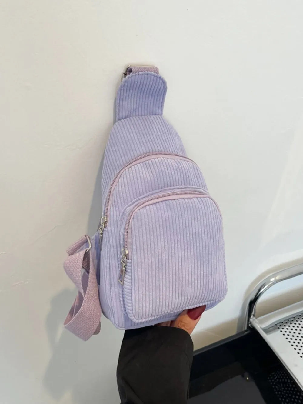 Lavender corduroy sling bag with zip pockets and adjustable strap.