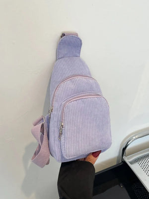 Lavender corduroy sling bag with zip pockets and adjustable strap.