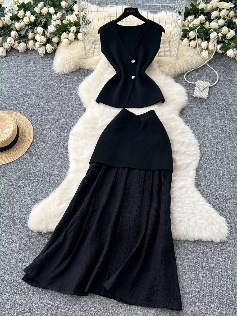 Black sheer two-piece set with V-neck sleeveless top and button details, paired with a flowing skirt.