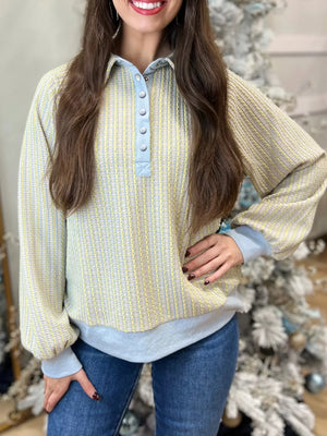 Buttoned half snap sweatshirt in light green with a textured stripe pattern and light blue collar and cuffs.