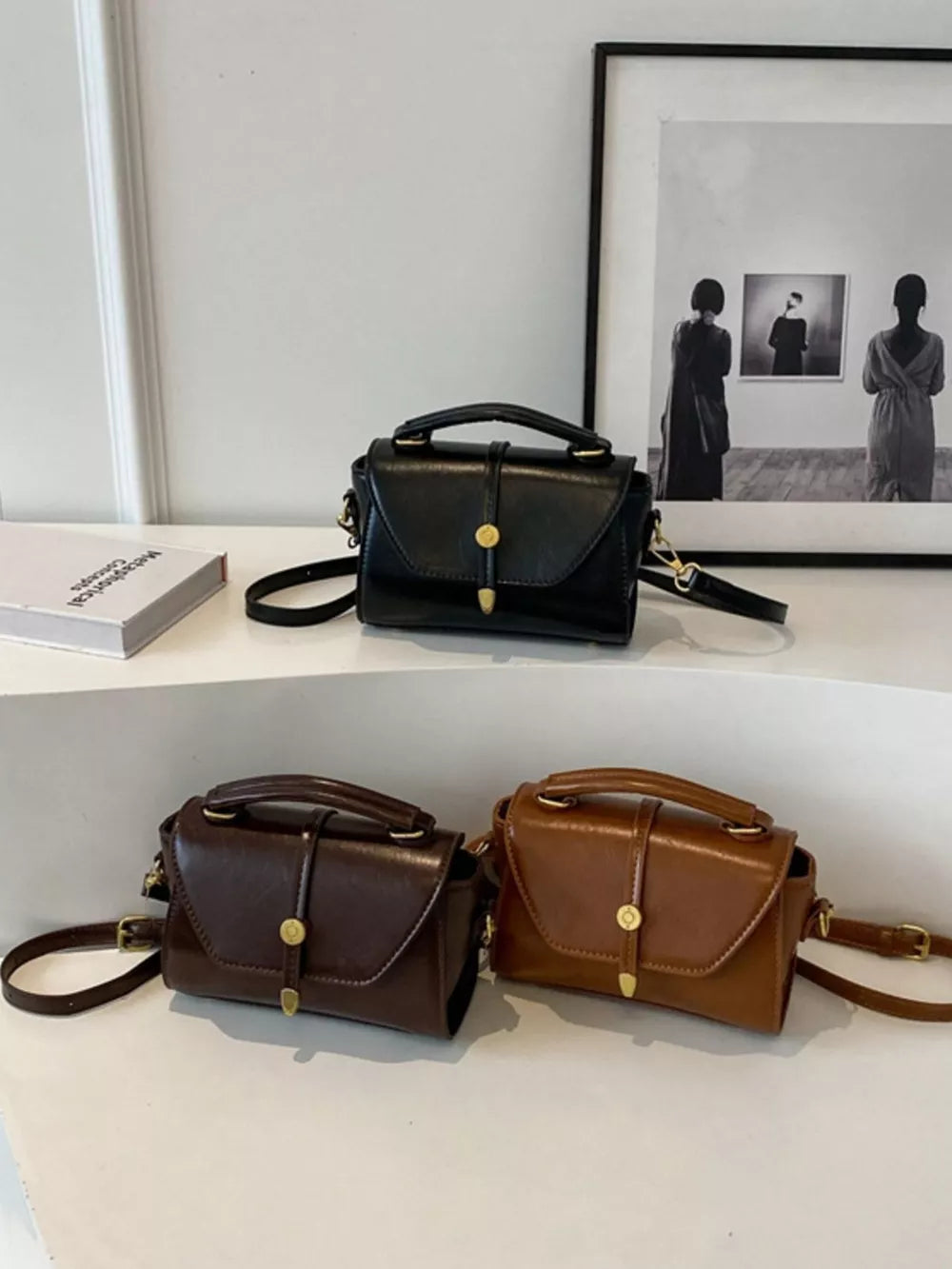Mini pu leather crossbody bag with clasp in brown and black, featuring a top handle and adjustable strap.