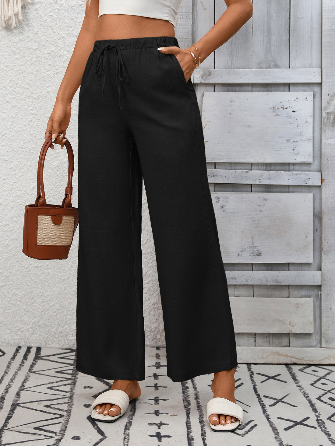 Black high-waist wide-leg pants with drawstring and pockets.