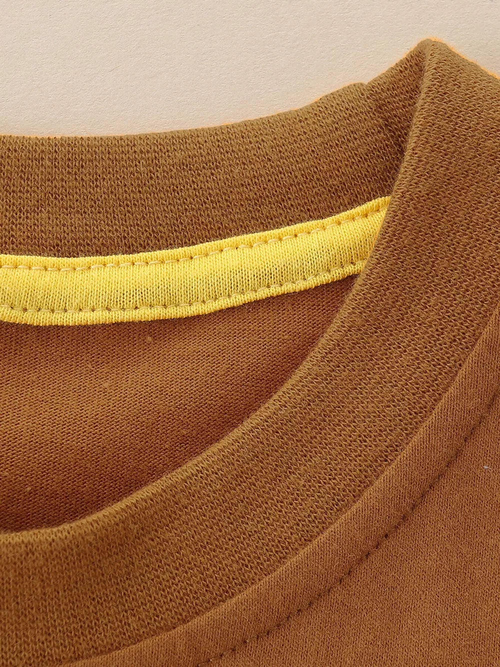 Brown cotton blend toddler tee with yellow trim detail at the crew neck.