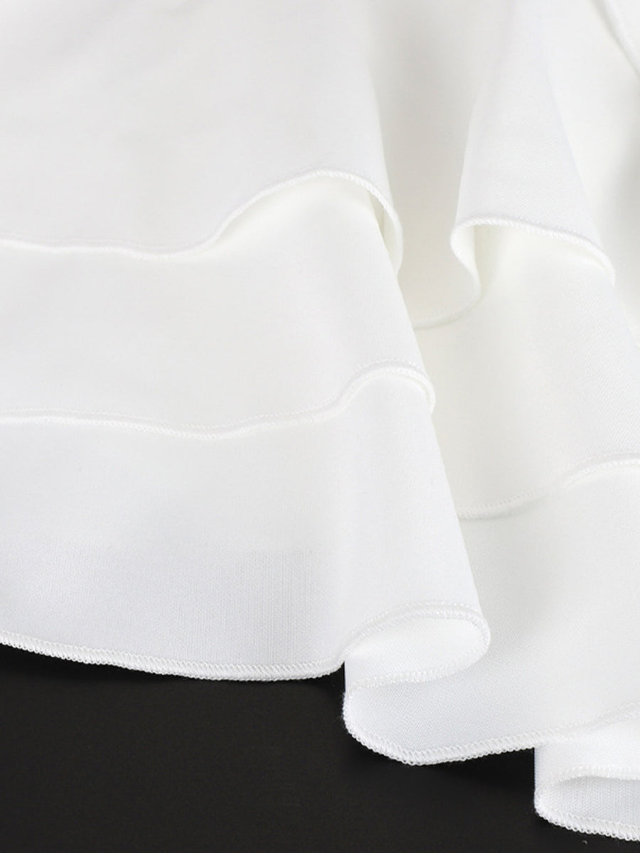 White mini dress with tiered ruffles and scalloped edges.