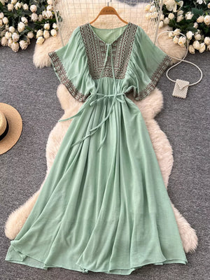 Mint green embroidered V-neck maxi dress with tie waist and flutter sleeves.