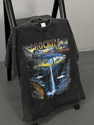 Black vintage wash graphic t-shirt with Rockies mountain and waterfall scene.