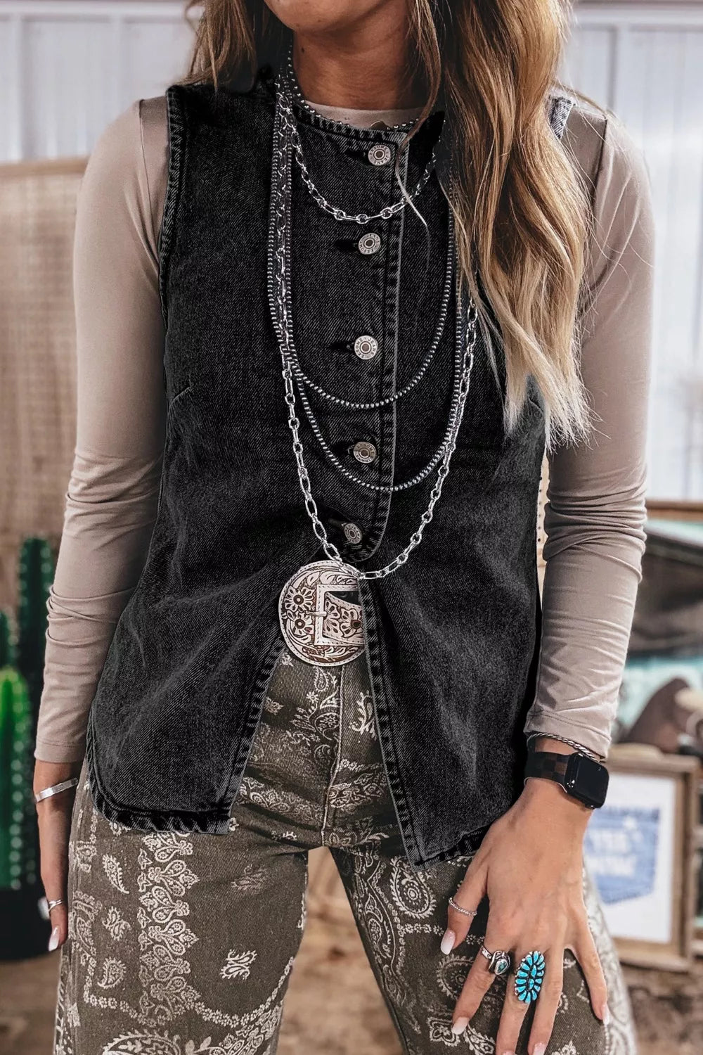 Black denim button-front vest with vintage wash and raw hem detail.