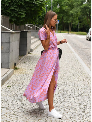 Wrap dress in lavender with an orange abstract print, short sleeves, V-neck, and high slit.