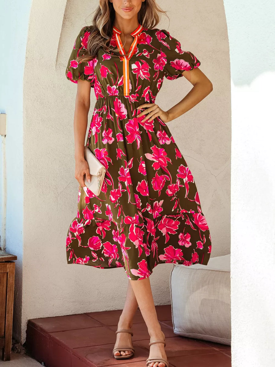 Print split neck dress with puff sleeves and tiered hem, featuring a floral pattern and contrasting trim.