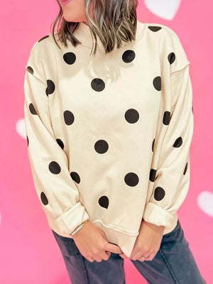 black sweatshirt featuring ribbed cuffs and polka dot