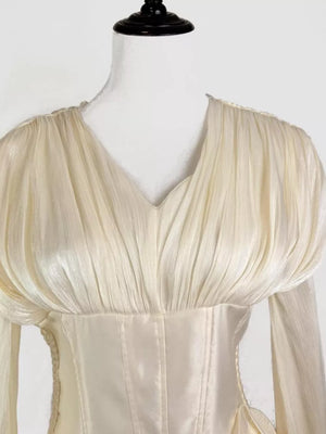 White cotton mini dress with corset waist and ruffled V-neck bodice.