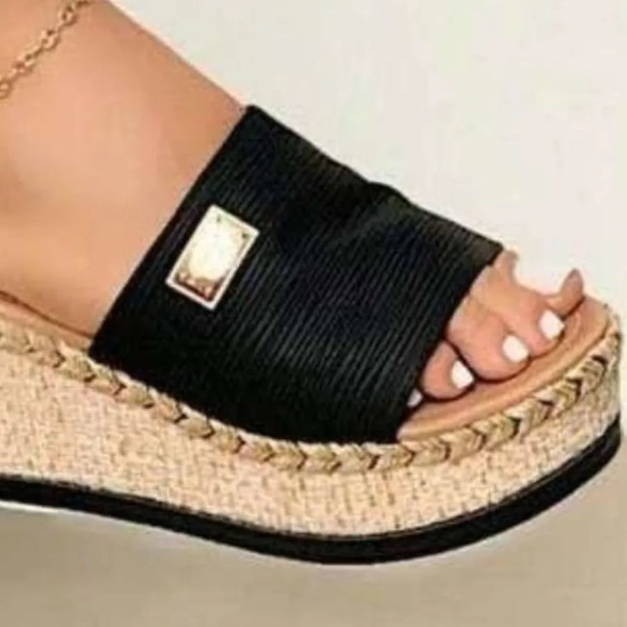 Black textured platform slides with metallic detail and espadrille trim.