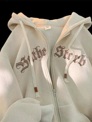 Apricot zip up hoodie with drawstring and gothic text graphic detail.