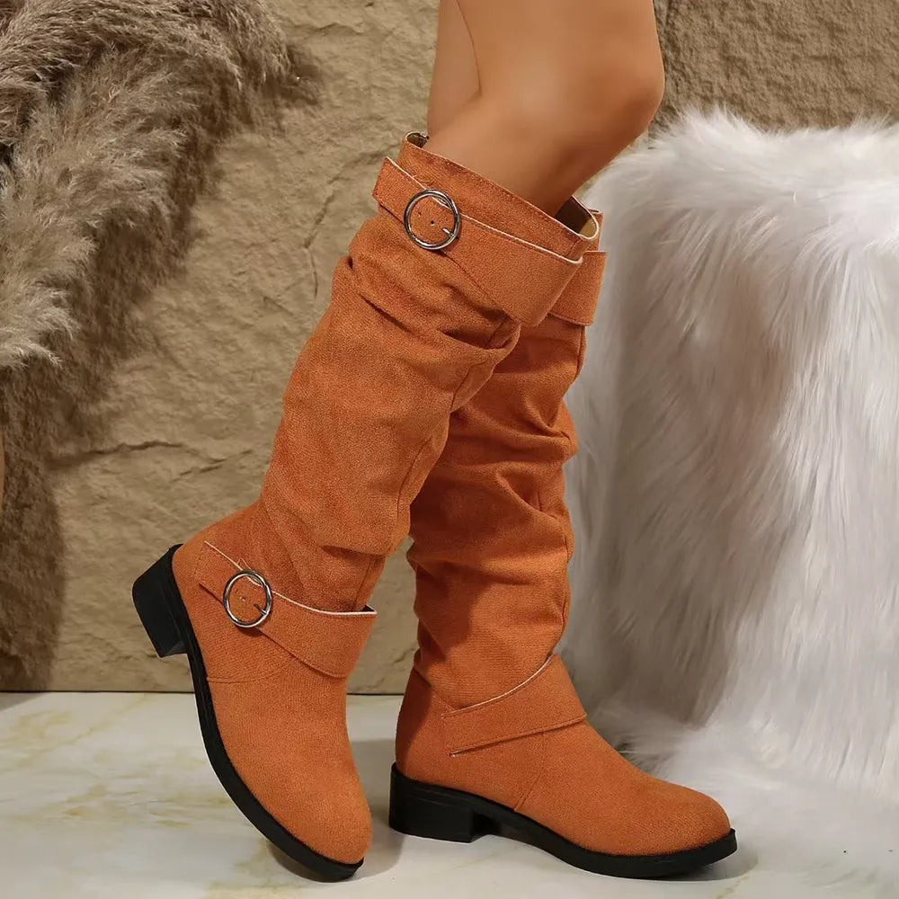 Slouchy knee-high boots in terracotta with buckle detail and flat heel.